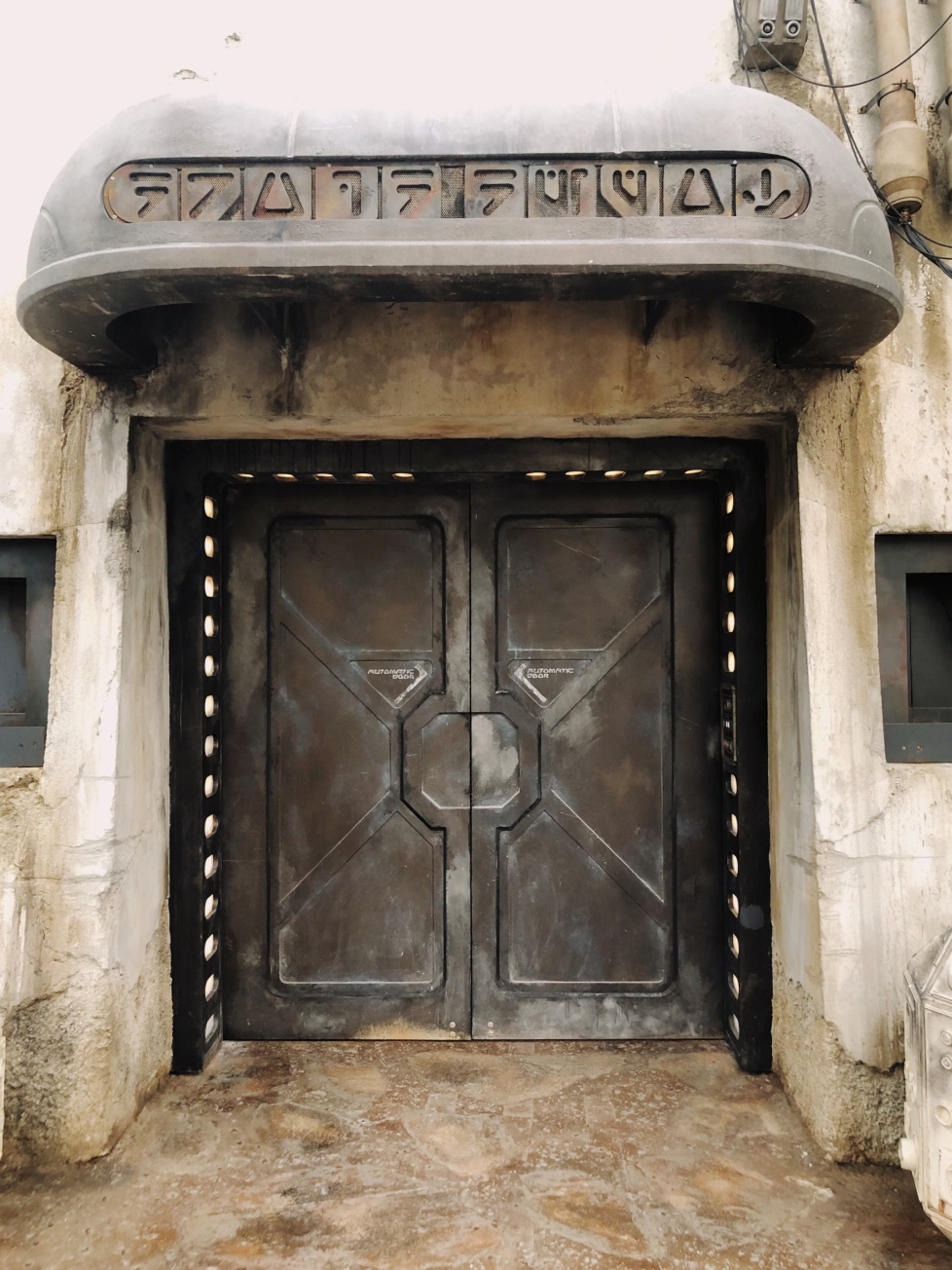 Daytime shot of door entrance to The Droid Depot inside of Star Wars: Galaxy's Edge at Disney's Hollywood Studios®. Lake Buena Vista, Florida.